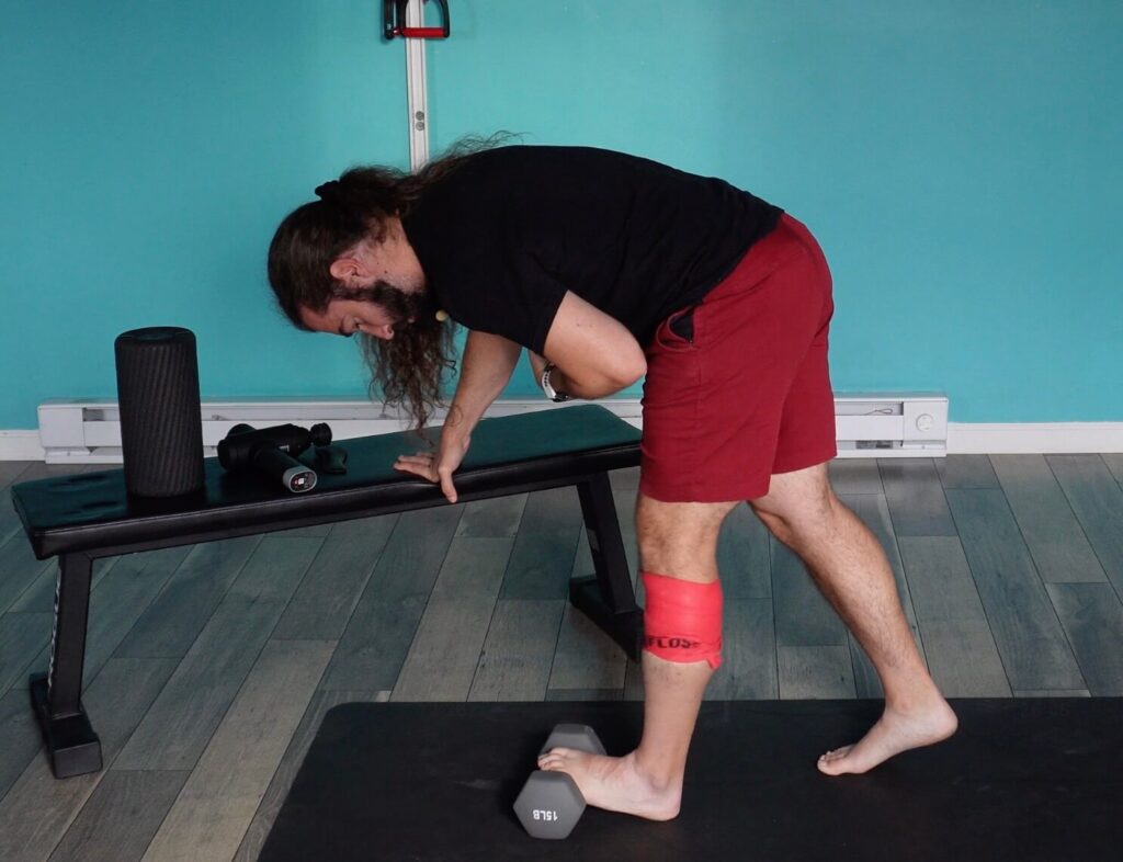 Dr. John dynamically stretching his calf muscle as a form of achilles tendinitis self-care